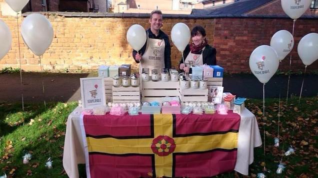 A stall in Northampton selling candles, on the recent Northamptonshire Day bedecked with the county flag